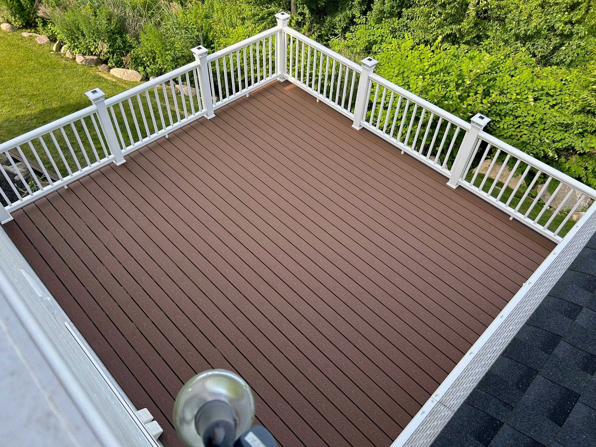 Brown composite deck with white railings, seen from above